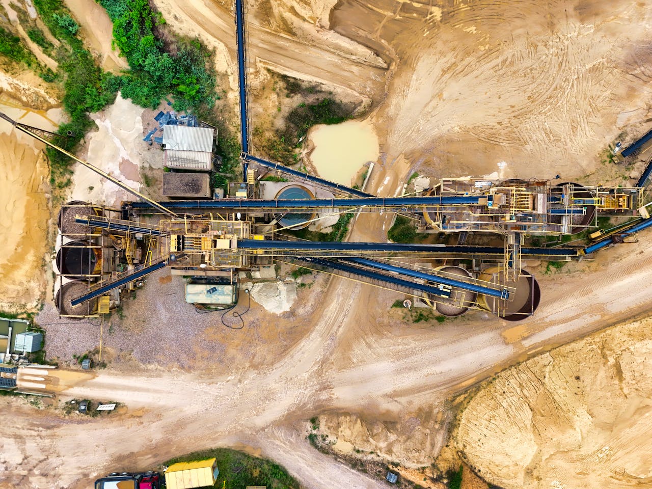 Top-down view of a sprawling industrial mining site featuring heavy machinery and detailed terrain.